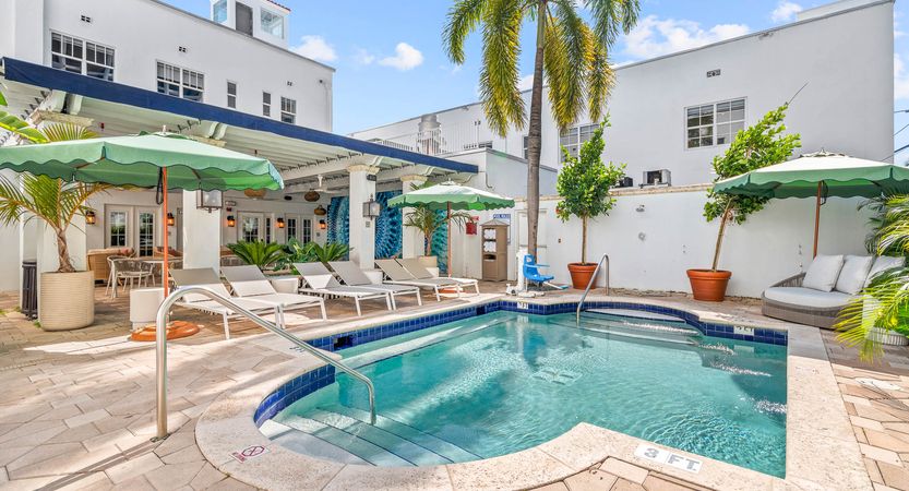 the pool courtyard with loungers and green umbrellas