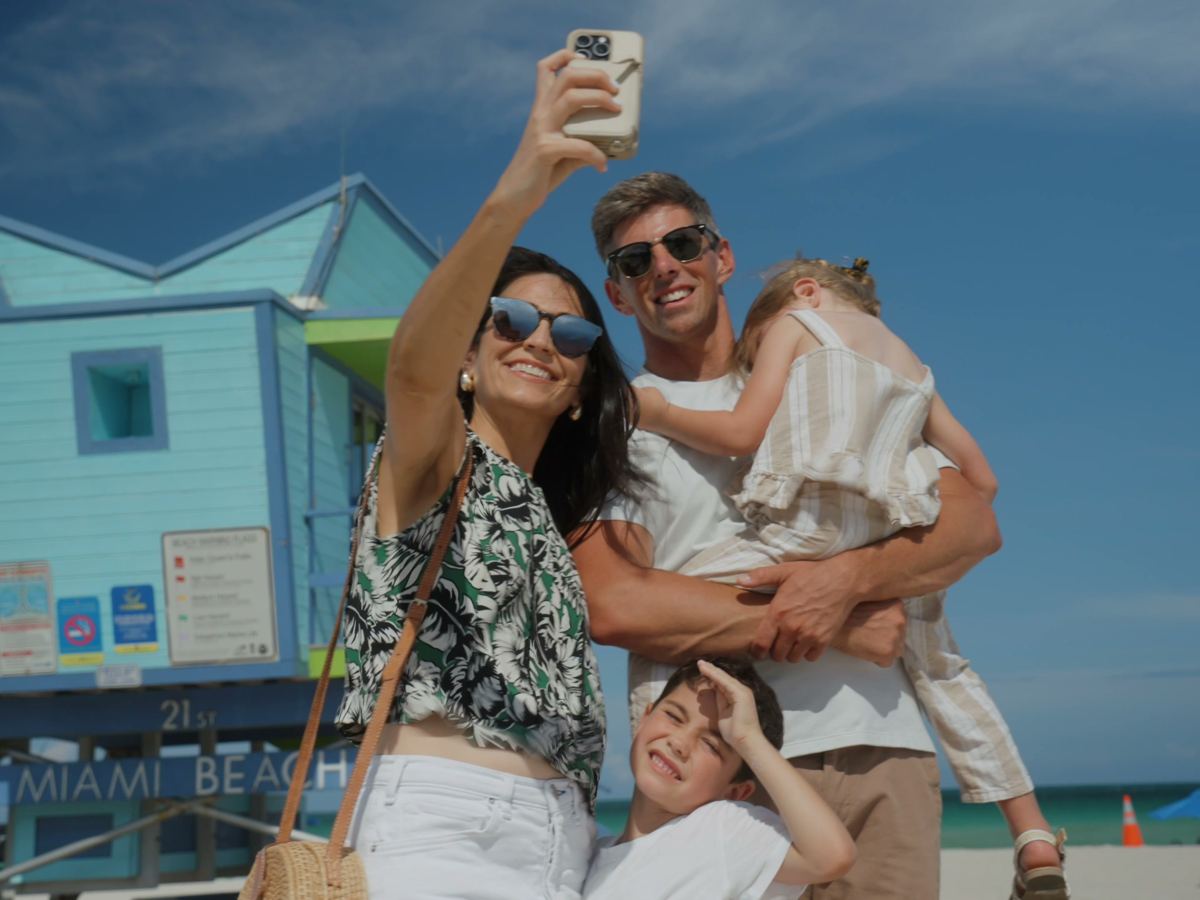 a family taking a selfie at a lifeguard tower on Miami Beach