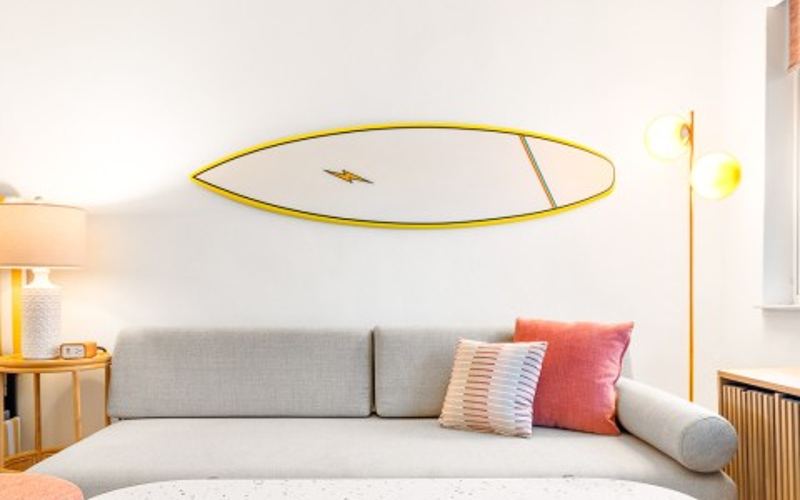 a suite living area with a surfboard on the wall